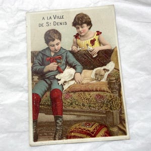 Final do século XIX - Old Chromo - Uma menina e um menino cuidando de um cachorrinho - A la Ville de Saint Denis - Cartão de visita vitoriano