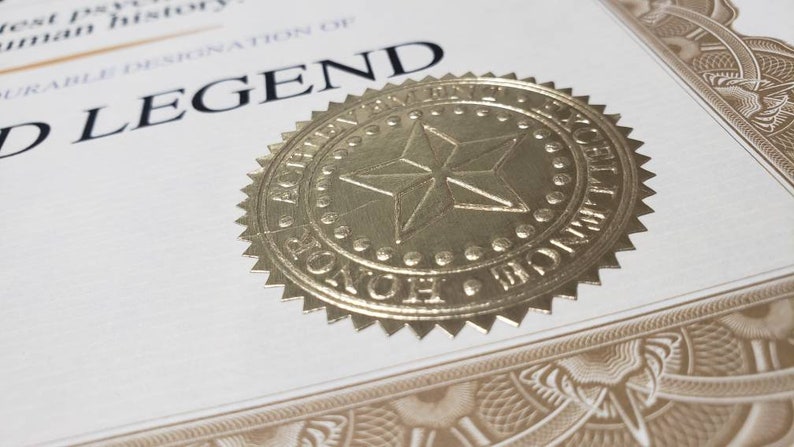 Puede incluir: Certificado con sello de l&aacute;mina dorada. El sello presenta una estrella y las palabras "ACHIEVEMENT EXCELLENCE HONOR". El certificado dice "WORLD LEGEND" en negrita negra. Borde decorativo.