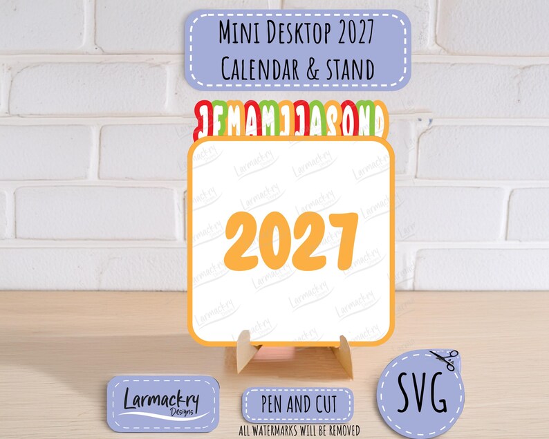 May include: A 2027 mini desktop calendar and stand featuring a square card with the year 2027 in large orange font. Above the card are colorful month initials. Includes labels reading Mini Desktop 2027 Calendar & Stand, Larmackry Designs, Pen and Cut, and SVG.