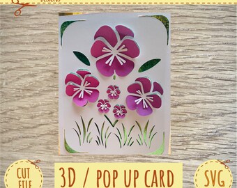 May include: A 3D pop-up card featuring a design of pink flowers with white centers and green leaves. The card is cut out to create a layered effect.