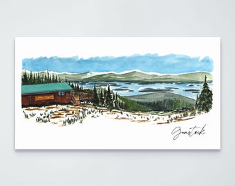 May include: A watercolor painting of a cabin with a green roof situated on a snowy hillside overlooking a lake and distant mountains. The scene features evergreen trees and the handwritten word Gunstock in the lower right corner of the print.