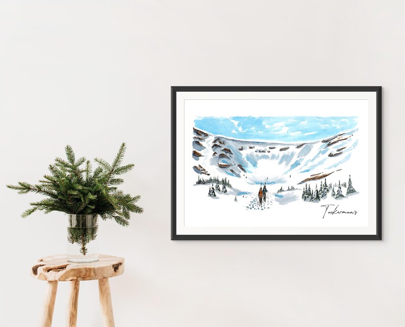 May include: A watercolour painting of a snowy mountain landscape with two figures hiking in the distance. The painting is framed in black and has the word "Tuckerman's" signed in the bottom right corner.