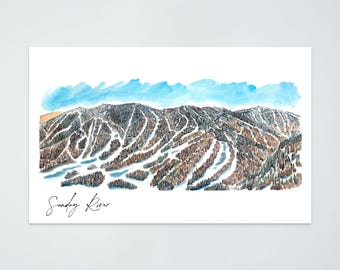 May include: Watercolor print of Sunday River ski resort. The artwork depicts the mountain with ski trails, trees, and a blue sky. The words "Sunday River" are written in cursive at the bottom of the print.