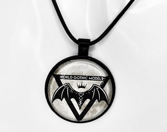 May include: Black necklace with a round pendant featuring a black bat with a crown and the text "WORLD GOTHIC MODELS".