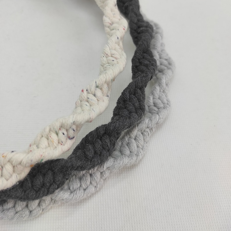 May include: Three twisted cords of rope in white, gray, and black. The white rope has colorful flecks throughout.
