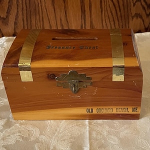 May include: A white ceramic mug with a black handle and the text "But First, Coffee" in a handwritten style. The mug is on a white surface. The mug is 4 inches tall.