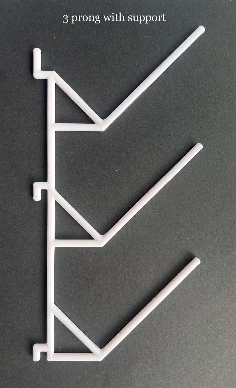 Pu&ograve; includere: Supporto per mensole in plastica bianca con tre punte. Il supporto ha una forma triangolare ed &egrave; progettato per sostenere mensole.