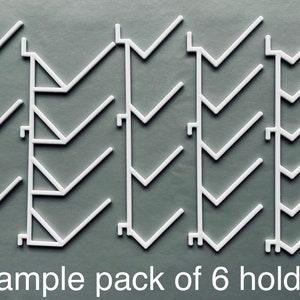 May include: A sample pack of six white plastic shelf dividers. The dividers are designed to create vertical sections on shelves.  Sample pack of 6 holders.