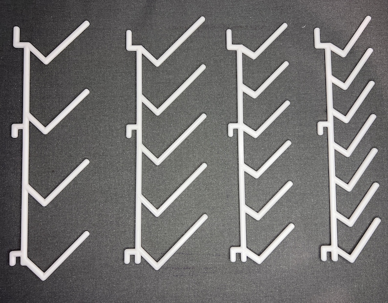 Pu&ograve; includere: Quattro divisori per mensole in plastica bianca con un design a zig-zag. Ogni divisore ha sette mensole.