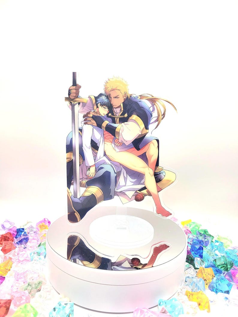 May include: A clear acrylic stand with a light inside, featuring a two-dimensional image of two men embracing. The man on the left is wearing a white shirt and blue pants, while the man on the right is wearing a blue and gold shirt and pants. The man on the right is holding a sword.