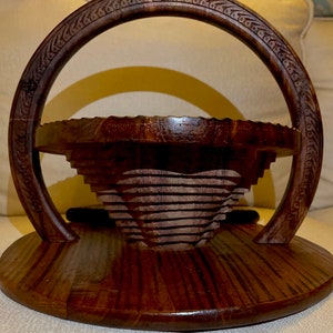 May include: A dark brown wooden serving tray with a carved heart design and a handle. The tray is made of wood and has a natural finish.