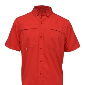 May include: A short-sleeved, bright red button-down shirt. The shirt has two chest pockets and a small loop on the left pocket. The fabric has a subtle textured pattern. The collar is button-down.