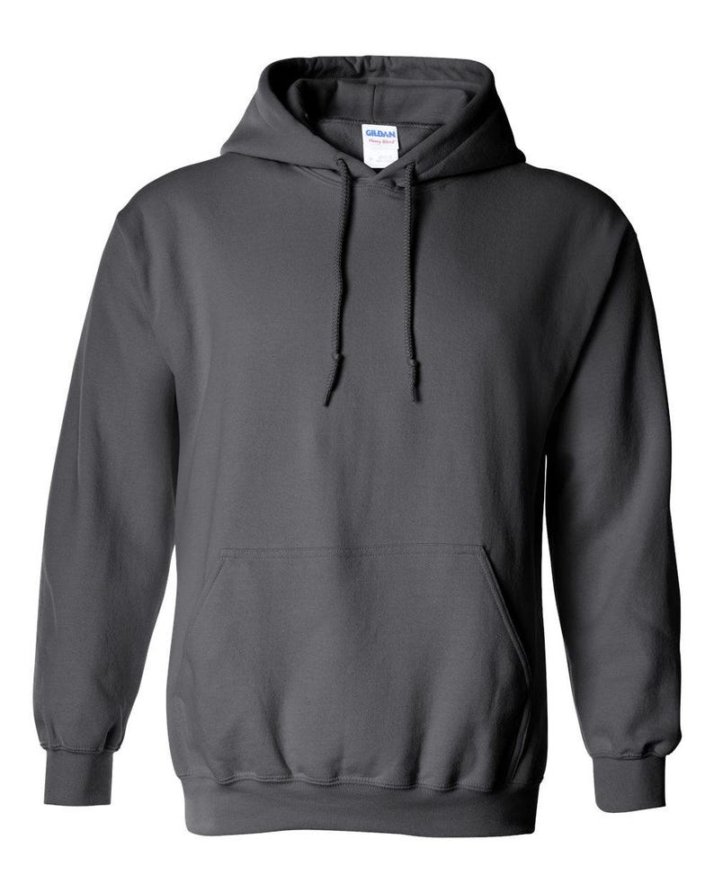 Puede incluir: Una sudadera con capucha gris oscuro con un bolsillo delantero y cord&oacute;n. La sudadera tiene pu&ntilde;os acanalados y un dobladillo inferior acanalado. La marca "Gildan" es visible en la etiqueta dentro de la capucha.