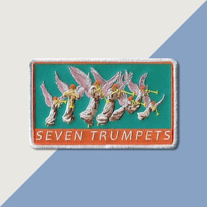 May include: A white embroidered patch with a green background featuring seven angels playing trumpets. The text "SEVEN TRUMPETS" is embroidered in orange below the angels.