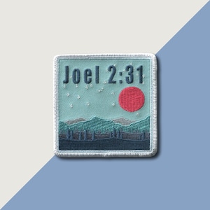Peut inclure: Un patch brodé bleu et blanc avec le texte "Joël 2:31" et un soleil rouge au-dessus d'une chaîne de montagnes.