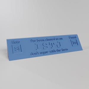 May include: A light blue desk sign with the text "I've been classed as an ISTJ don't argue with the facts." The sign also features the words "Here Si" and "Parent Te" in a minimalist design.