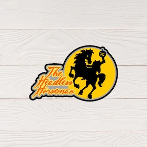 May include: A black silhouette of a headless horseman riding a horse with a jack-o-lantern in its hand. The image is set against a yellow circle with a gray outline. The text "The Headless Horseman" is written in orange and black below the circle.