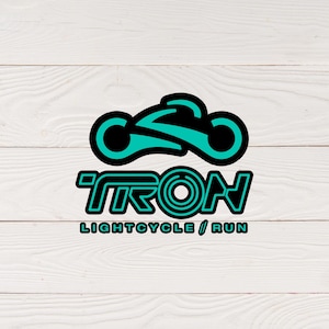 May include: A teal and black graphic of a futuristic motorcycle with the word "TRON" in teal and black block letters. Below the word "TRON" is the text "LIGHTCYCLE / RUN" in teal and black.