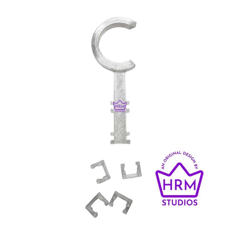 Puede incluir: Un objeto en forma de llave, impreso en 3D, de color gris claro, con una parte superior curvada y un mango texturizado. Tambi&eacute;n hay tres piezas m&aacute;s peque&ntilde;as en forma de C a juego. La imagen incluye un logotipo p&uacute;rpura que dice "HRM STUDIOS".
