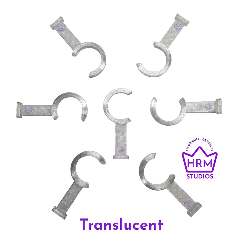 Puede incluir: Ganchos transl&uacute;cidos plateados con un dise&ntilde;o curvo, dispuestos sobre un fondo blanco. Cada gancho tiene una base rectangular con un logotipo de corona. La imagen tambi&eacute;n incluye el texto "Translucent" y un logotipo que dice "HRM Studios".
