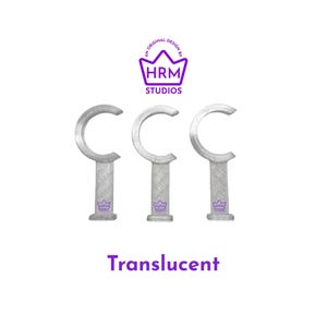 Puede incluir: Tres soportes transl&uacute;cidos en forma de C para barras de cortina. Los soportes son plateados y tienen un aspecto texturizado. El texto "Translucent" est&aacute; debajo. Encima, un logotipo morado dice "HRM Studios."