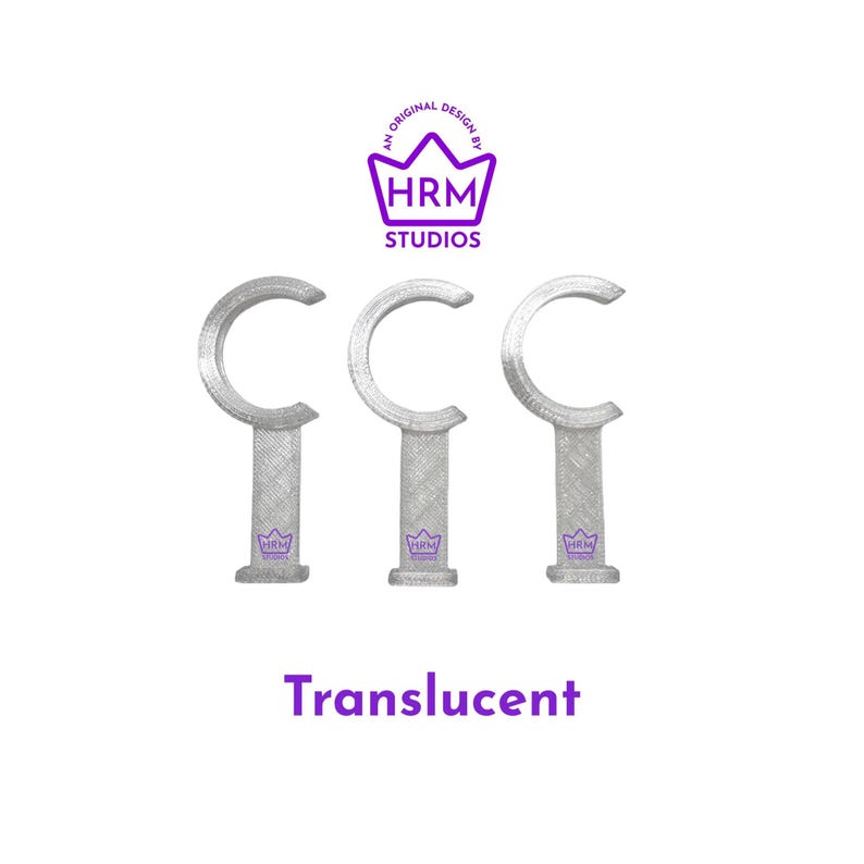 Puede incluir: Tres soportes transl&uacute;cidos en forma de C para barras de cortina. Los soportes son plateados y tienen un aspecto texturizado. El texto "Translucent" est&aacute; debajo. Encima, un logotipo morado dice "HRM Studios."