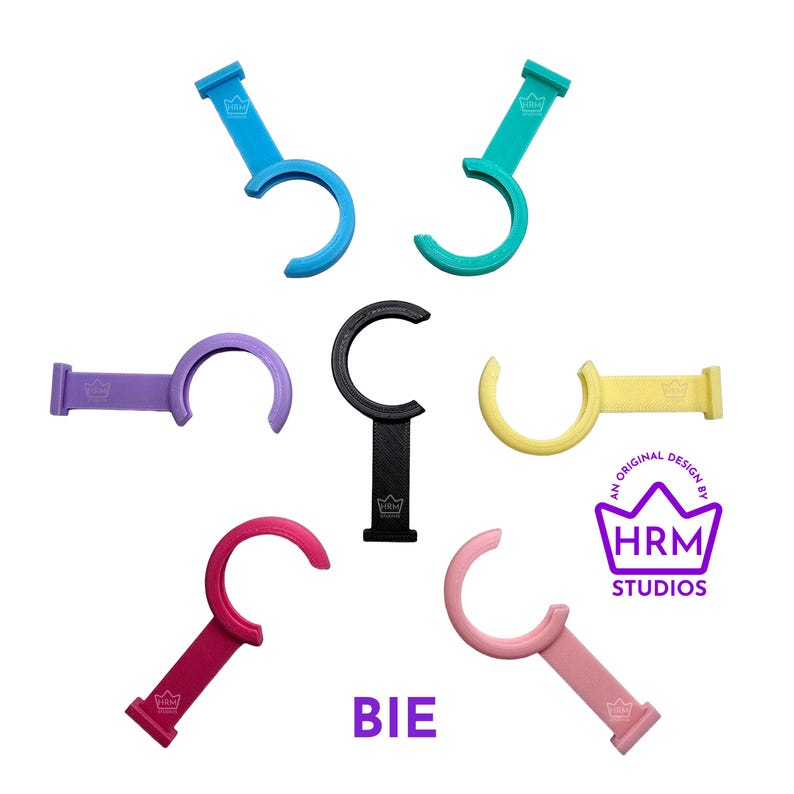 Puede incluir: Una colecci&oacute;n de abridores de botellas curvos y coloridos en varios tonos, incluyendo azul, verde, morado, negro, amarillo, rojo y rosa. Cada abridor presenta un mango y un dise&ntilde;o de gancho curvo. Tambi&eacute;n se ve el texto "BIE" y un logotipo.