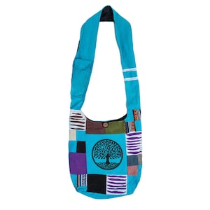 May include: A blue patchwork shoulder bag with a tree of life design. The bag has a variety of colors and patterns, including purple, green, black, and white.