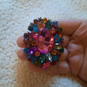 Vibrant Natasha brooch features a striking large magenta central stone surrounded by a constellation of smaller, multi-colored rhinestones