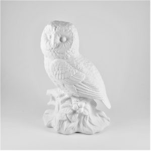 May include: White ceramic owl figurine perched on a branch with berries. The owl has detailed feathers and realistic eyes.