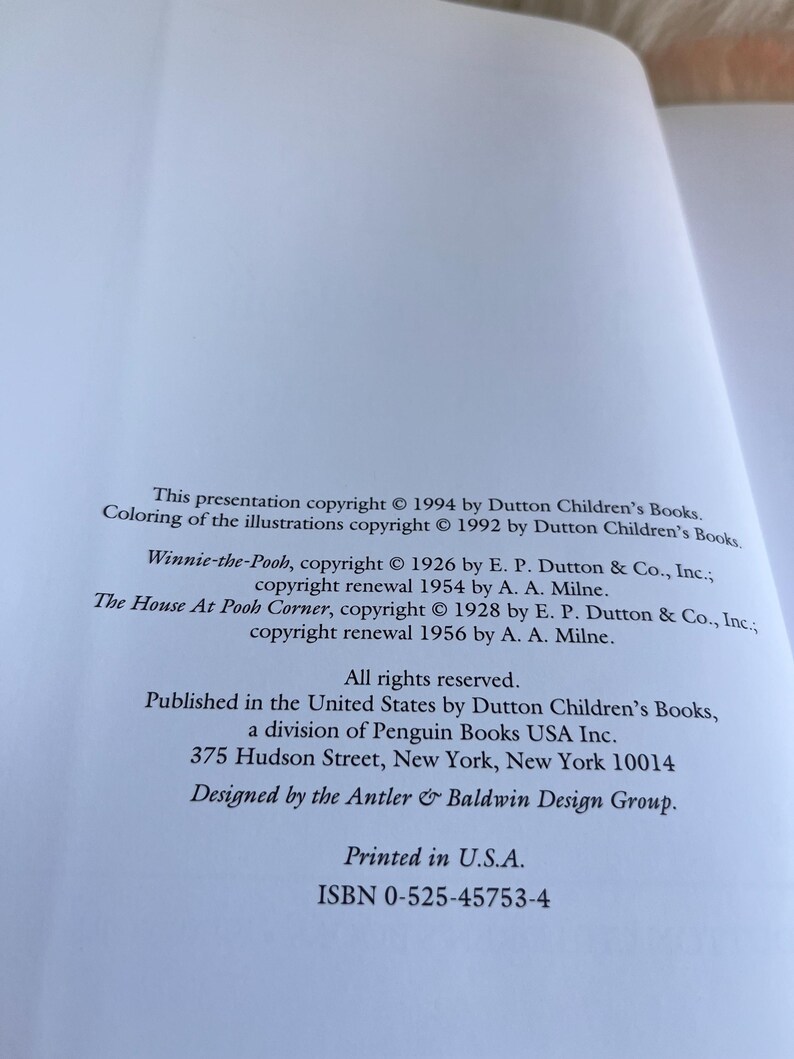 Puede incluir: P&aacute;gina de libro abierta con informaci&oacute;n de derechos de autor para libros infantiles, incluyendo "Winnie-the-Pooh" y "The House At Pooh Corner". El texto tambi&eacute;n incluye la direcci&oacute;n del editor en Nueva York y el ISBN.