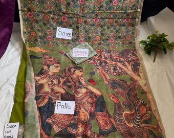 May include: A green saree with a detailed floral pattern and a painted scene of figures and a bird. The saree includes a blouse piece. The text "Saree", "Blouse Piece", and "Pallu" are visible.