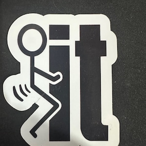 Puede incluir: Una pegatina blanca con una figura de palo negra haciendo el dedo medio y la palabra "it" en negro.