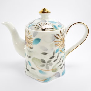 May include: White porcelain teapot with a gold and blue floral design. The teapot has a lid with a gold knob.