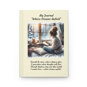 May include: A journal with the text "My Journal Where Dreams Unfold" on the cover. The cover features an illustration of a person writing by a window with a teddy bear and a poem.