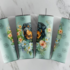 May include: Four stainless steel tumblers with a light blue background and floral designs. Each tumbler features a Rottweiler dog with a floral wreath around its head.