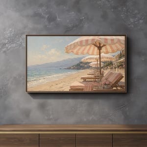 May include: A rectangular framed landscape painting depicting a sunny beach scene with rows of pink and white striped umbrellas over wooden lounge chairs. The artwork shows a calm blue ocean, sandy shoreline, and distant mountains under a clear sky.