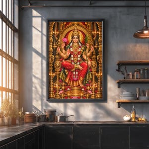 May include: A framed wall art print depicting the Hindu goddess Lakshmi seated on an ornate golden throne, wearing a red and green sari with gold jewelry, surrounded by glowing oil lamps and pink lotus flowers in a detailed temple setting.