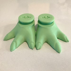 Standard feet with pegs, in regular Baby Yoda green color.