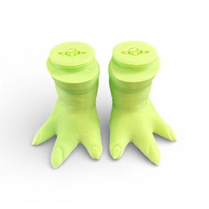 May include: Two lime green hand-shaped bottle stoppers. Each stopper has a round top with a small design and a hand-shaped base with three fingers. The stoppers are made of a solid, smooth material and are set against a white background.