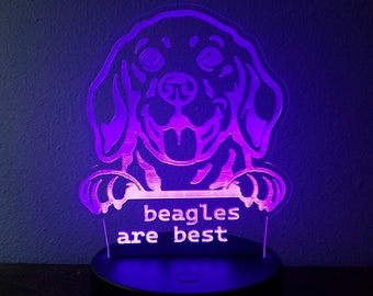 May include: A purple and white LED night light shaped like a beagle dog with the text "beagles are best" on a black base.