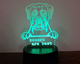 May include: A green LED night light featuring a white silhouette of a boxer dog. The dog is holding a sign that reads "boxers are best".
