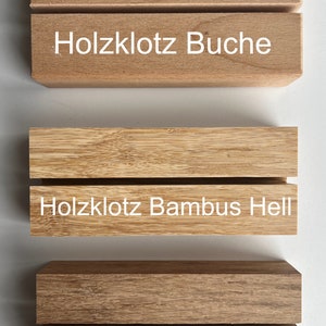 Puede incluir: Tres bloques de madera con ranuras horizontales. El bloque superior es de color marr&oacute;n claro con el texto "Holzklotz Buche". El bloque central es de color beige claro con el texto "Holzklotz Bambus Hell". El bloque inferior es de color marr&oacute;n oscuro con el texto "Holzklotz Bambus Dunkel".