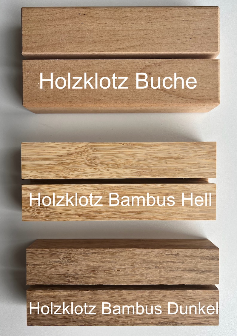 Puede incluir: Tres bloques de madera con ranuras horizontales. El bloque superior es de color marr&oacute;n claro con el texto "Holzklotz Buche". El bloque central es de color beige claro con el texto "Holzklotz Bambus Hell". El bloque inferior es de color marr&oacute;n oscuro con el texto "Holzklotz Bambus Dunkel".
