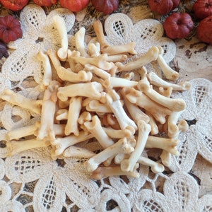 May include: A pile of small, white, bone-like objects, resembling animal bones, on a white lace doily.