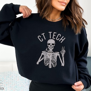 May include: Black sweatshirt with a skeleton holding a coffee cup with a radiation symbol. The text "CT TECH" is above the skeleton.