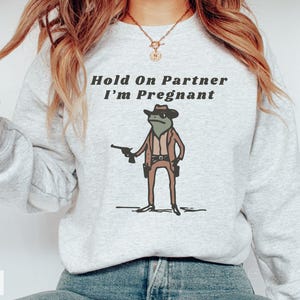 Hold On Partner I'm Pregnant Sweatshirt Funny Pregnancy Reveal Shirt Cowboy Frog Pregnancy Announcement Meme Maternity Gift Expecting Baby Ash
