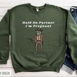 Hold On Partner I'm Pregnant Sweatshirt Funny Pregnancy Reveal Shirt Cowboy Frog Pregnancy Announcement Meme Maternity Gift Expecting Baby Military Green