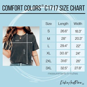 May include: A Comfort Colors C1717 size chart with measurements in inches. The chart includes sizes S to 3XL, with corresponding lengths and widths. A person is wearing a dark gray t-shirt. The text "Duke And Pine LLC" is at the bottom.