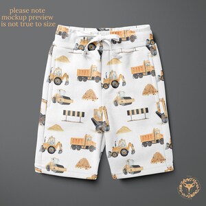 May include: White shorts with a yellow construction vehicle pattern. The pattern includes dump trucks, excavators, and road rollers.